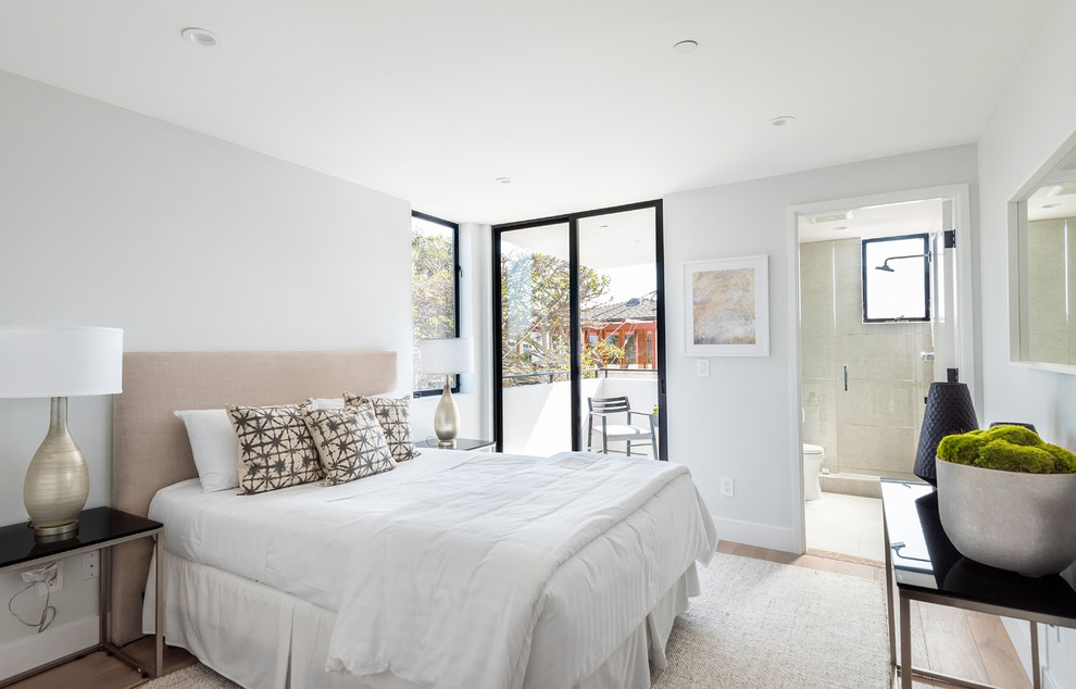 Réalisation d'une chambre design avec un mur blanc, parquet clair et un sol beige.
