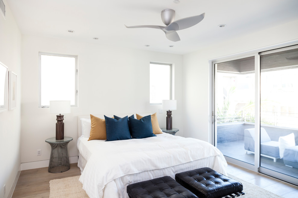 This is an example of a contemporary guest bedroom in Los Angeles with white walls, light hardwood flooring and beige floors.