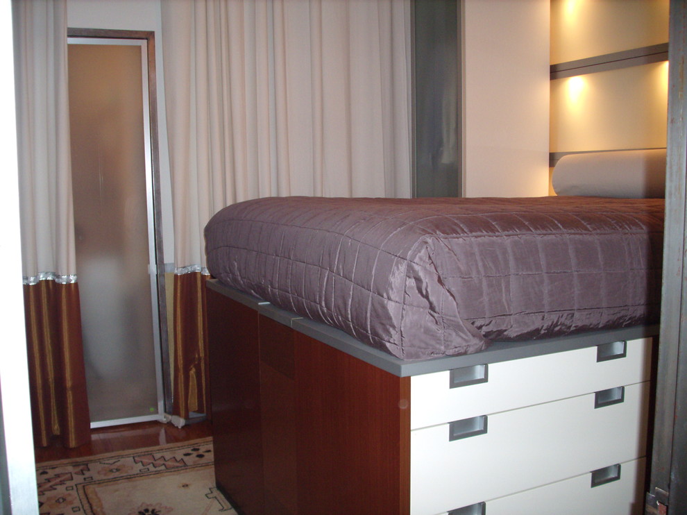 Diseño de dormitorio moderno pequeño con paredes azules y suelo de madera en tonos medios