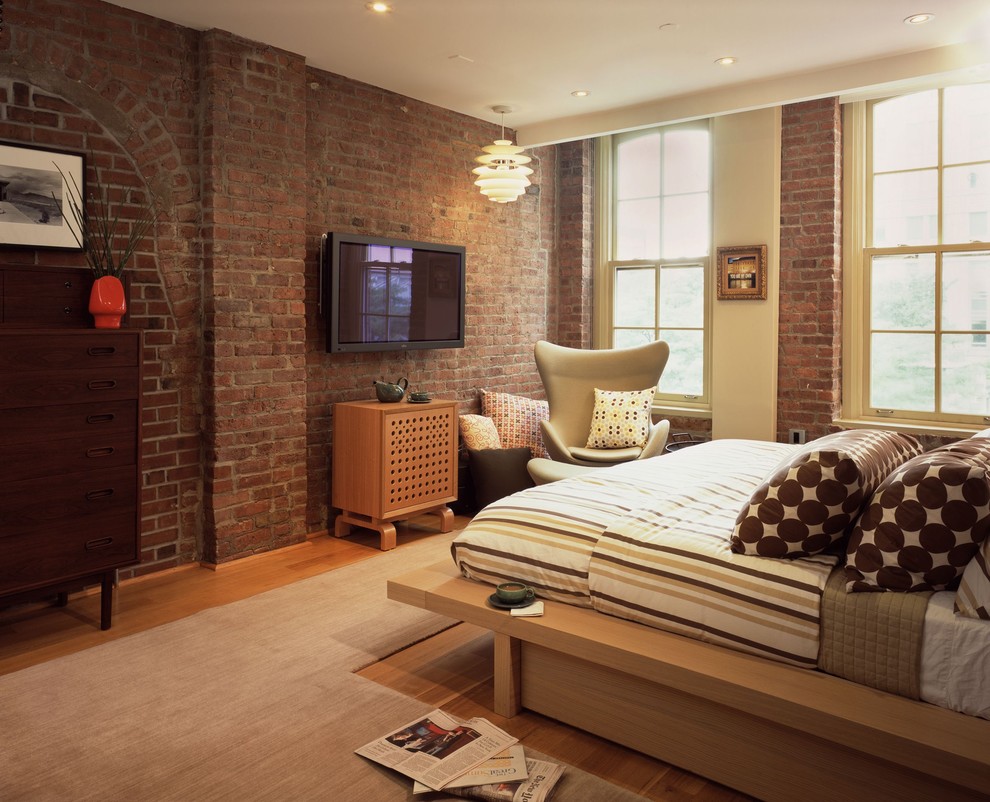 Idée de décoration pour une chambre urbaine avec un mur beige et un sol en bois brun.