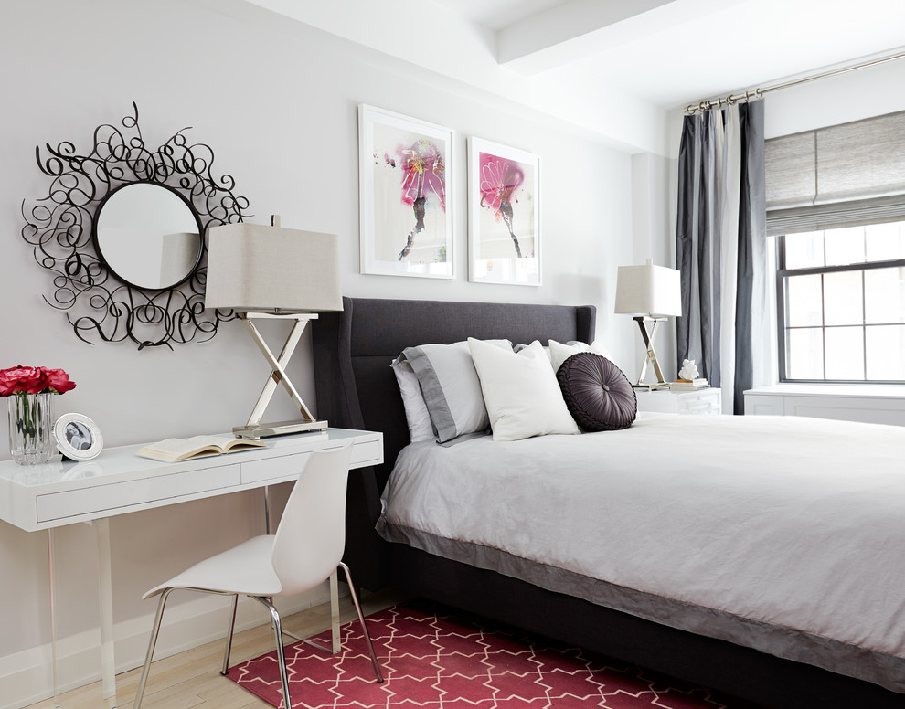 На фото: спальня в современном стиле с белыми стенами, светлым паркетным полом и рабочим местом с