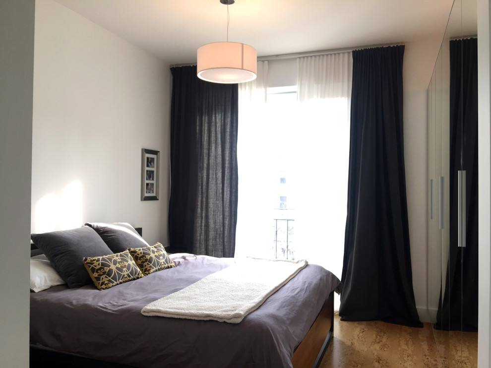 Пример оригинального дизайна: хозяйская спальня в скандинавском стиле с белыми стенами, пробковым полом, горизонтальным камином и фасадом камина из бетона