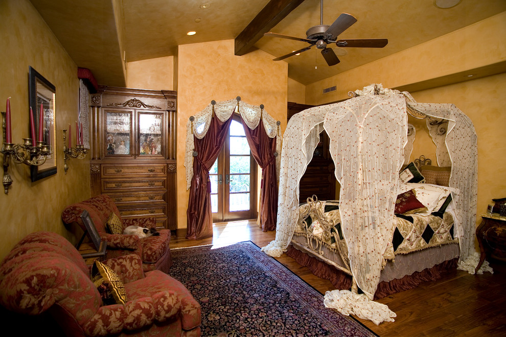 Victorian bedroom in Orange County with beige walls and dark hardwood flooring.