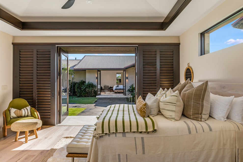 Esempio di una camera da letto tropicale con pareti beige, parquet chiaro e pavimento beige
