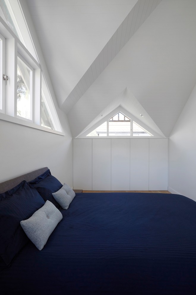 Imagen de dormitorio principal contemporáneo de tamaño medio sin chimenea con paredes blancas, suelo de madera clara y suelo beige