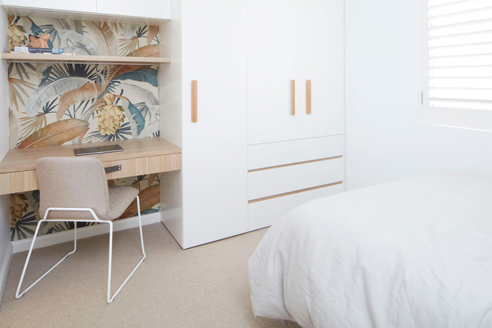 Modern inredning av ett sovrum, med vita väggar, heltäckningsmatta och beiget golv