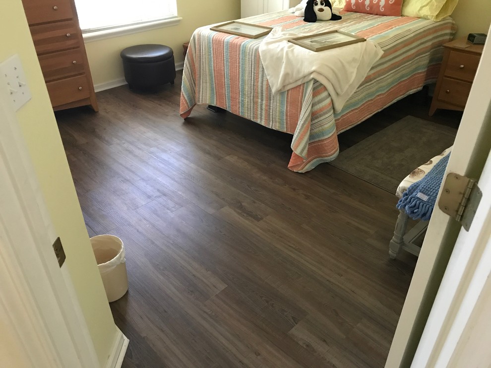 Example of a small classic guest vinyl floor and brown floor bedroom design in Jacksonville with yellow walls