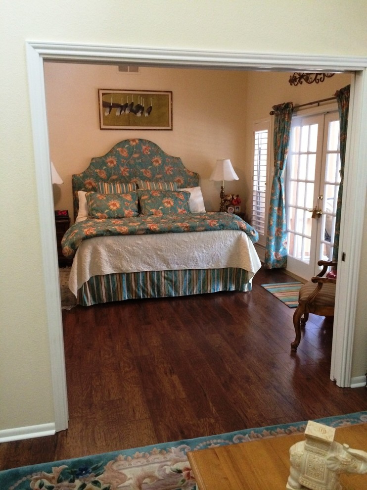 Diseño de dormitorio principal costero de tamaño medio con paredes beige y suelo laminado