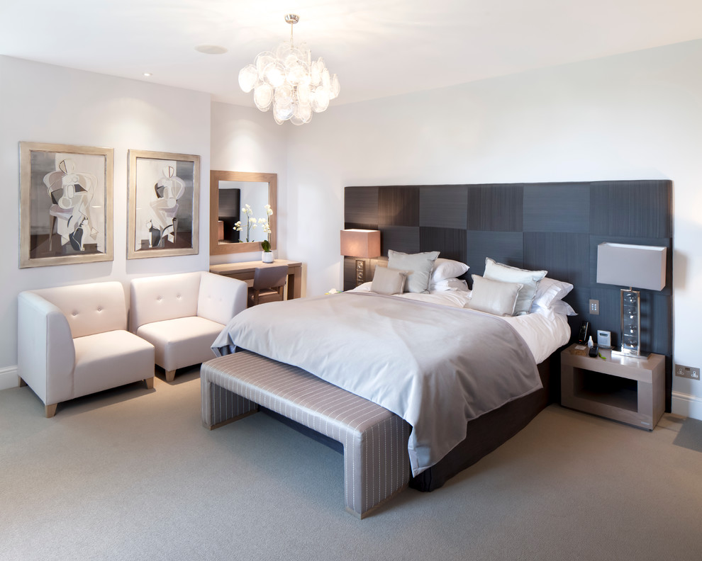 This is an example of a contemporary bedroom in Gloucestershire with white walls, carpet and no fireplace.