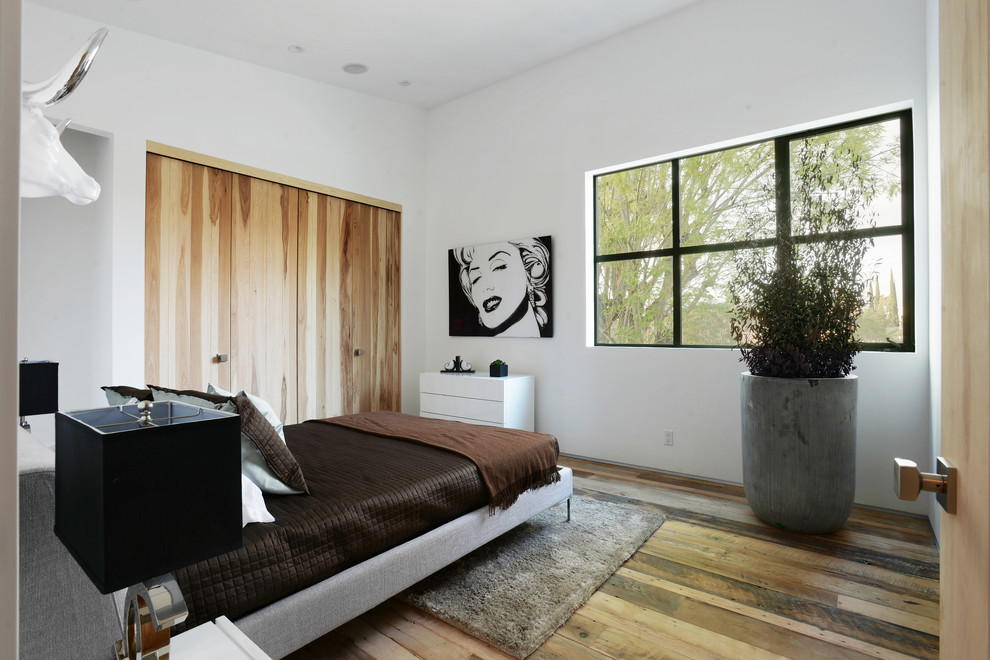 Example of a mid-sized trendy guest light wood floor bedroom design in Los Angeles with white walls and no fireplace