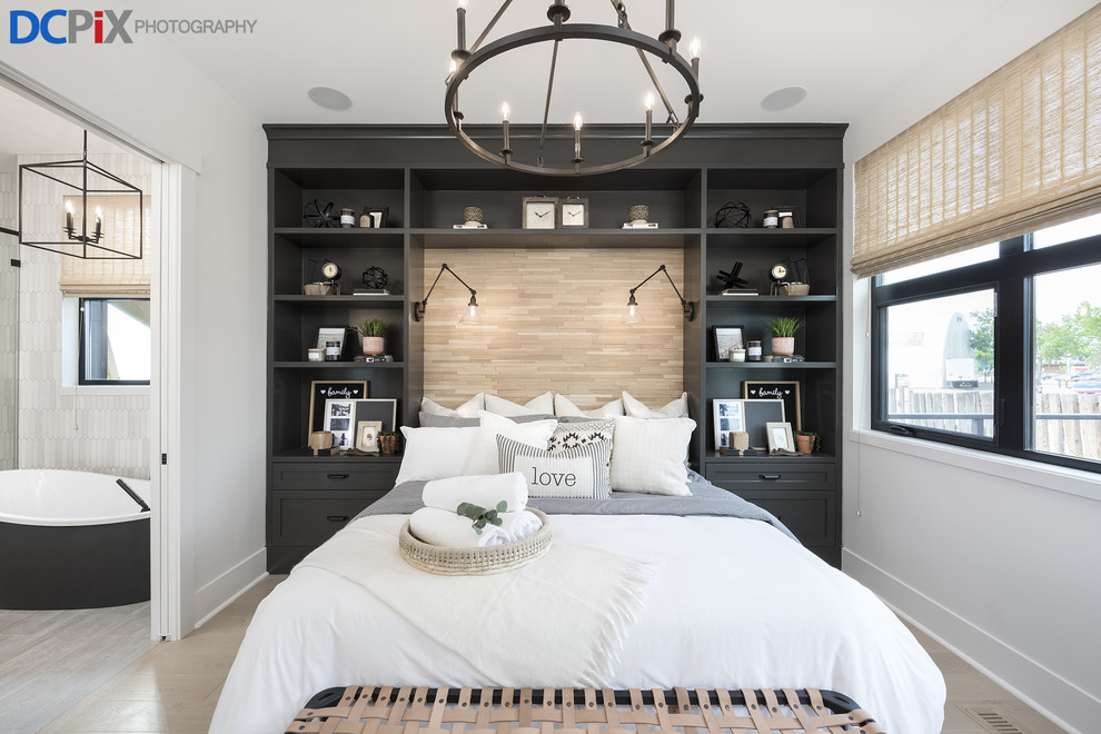 Großes Modernes Hauptschlafzimmer mit weißer Wandfarbe, hellem Holzboden und beigem Boden in Calgary
