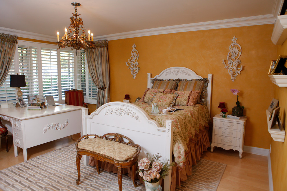 Diseño de dormitorio tipo loft bohemio de tamaño medio sin chimenea con paredes amarillas y suelo de madera clara