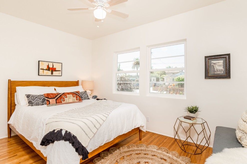 ロサンゼルスにあるトランジショナルスタイルのおしゃれな寝室 (白い壁、無垢フローリング) のインテリア