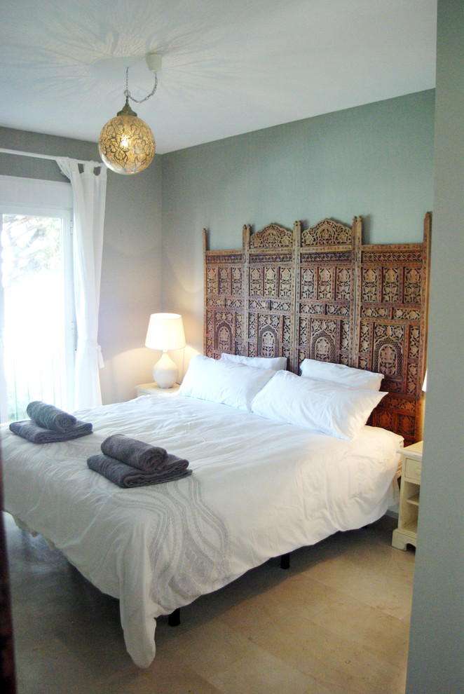Ejemplo de dormitorio principal exótico de tamaño medio sin chimenea con paredes grises