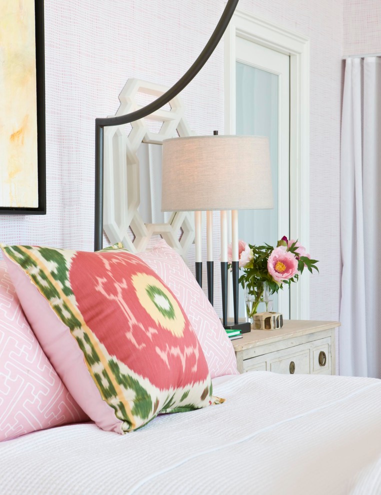 This is an example of a large beach style master bedroom in Boston with pink walls and medium hardwood flooring.