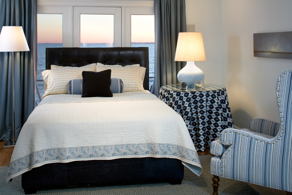 Inspiration for a mid-sized coastal guest medium tone wood floor bedroom remodel in Boston with white walls