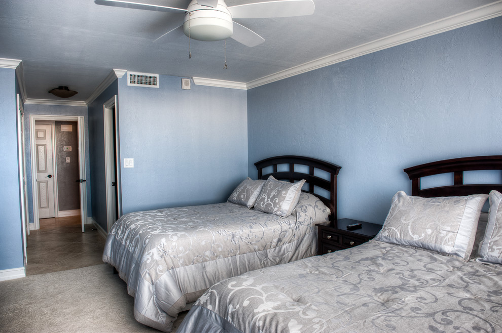 Photo of a medium sized retro guest bedroom with blue walls, carpet and beige floors.