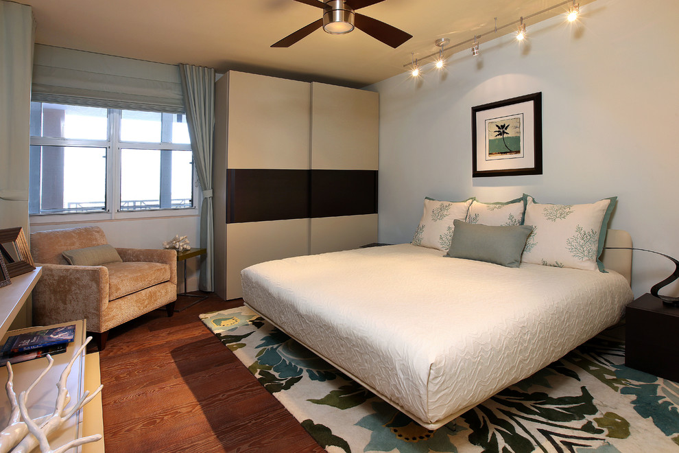 Imagen de habitación de invitados costera de tamaño medio sin chimenea con paredes blancas y suelo de madera en tonos medios