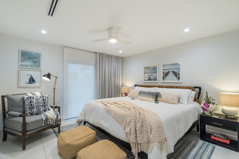 Imagen de dormitorio principal costero de tamaño medio con paredes blancas, suelo de baldosas de porcelana y suelo blanco
