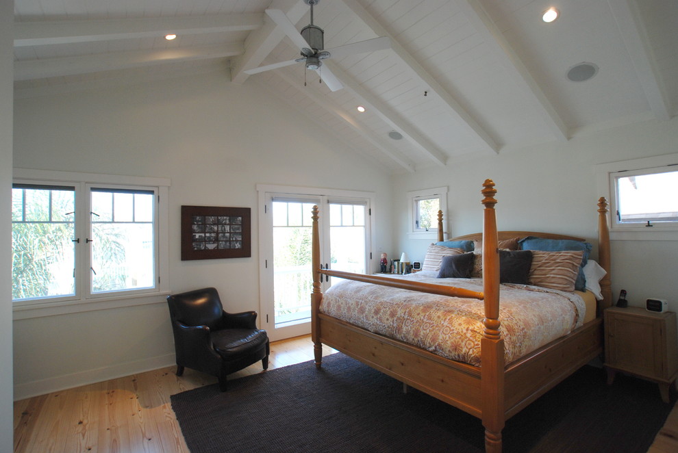 Diseño de dormitorio principal tropical con paredes blancas y suelo de madera clara