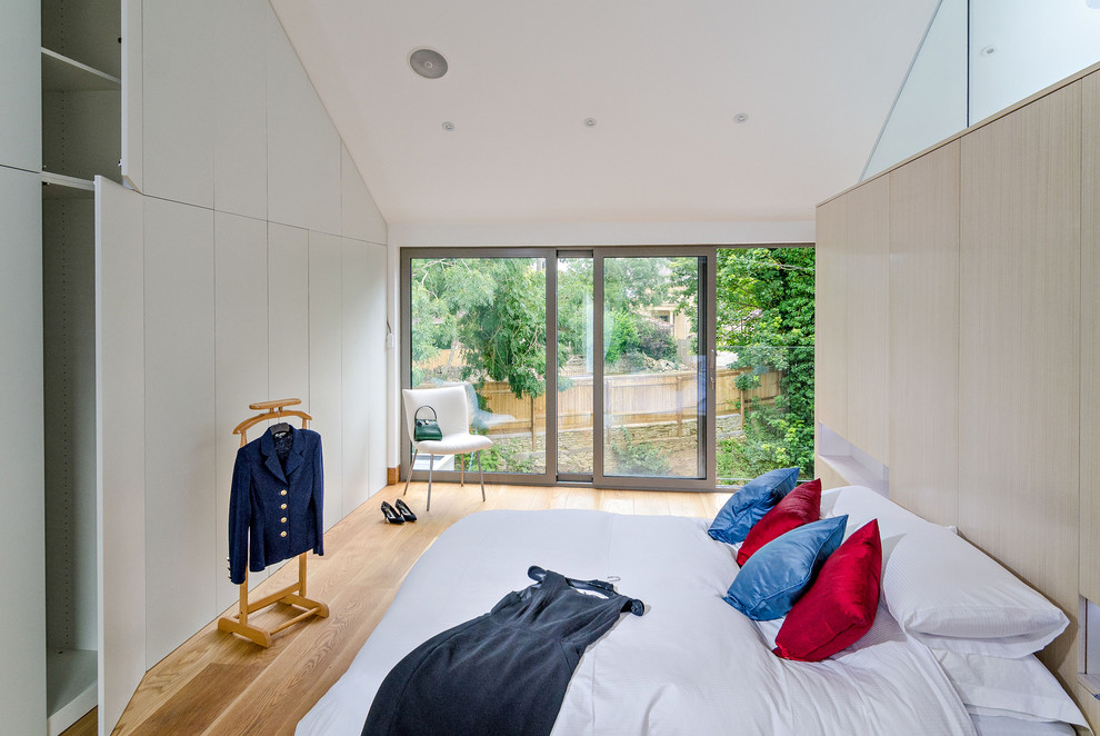 Modernes Schlafzimmer mit weißer Wandfarbe, braunem Holzboden und braunem Boden in Wiltshire