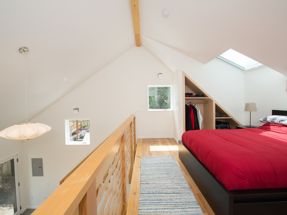 Esempio di una camera da letto stile loft minimalista di medie dimensioni con pareti bianche, parquet chiaro, nessun camino e pavimento marrone
