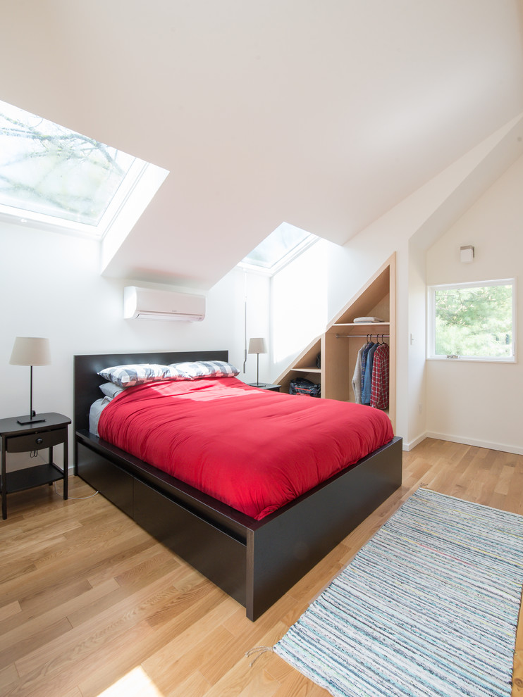 Foto di una camera da letto stile loft minimalista di medie dimensioni con pareti bianche, parquet chiaro, nessun camino e pavimento marrone