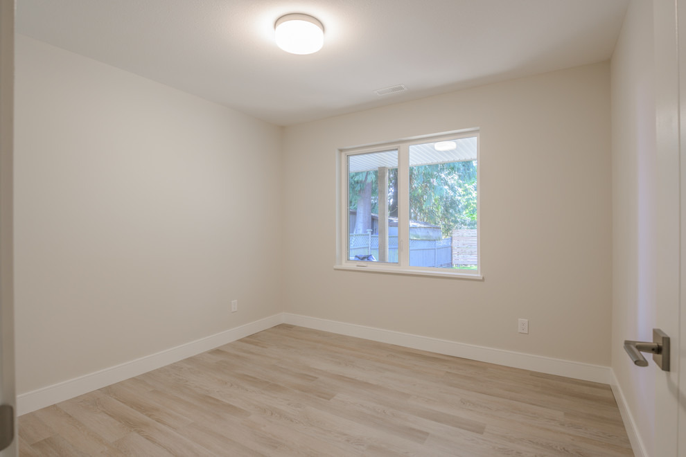 Mid-sized minimalist medium tone wood floor and brown floor bedroom photo in Other with beige walls