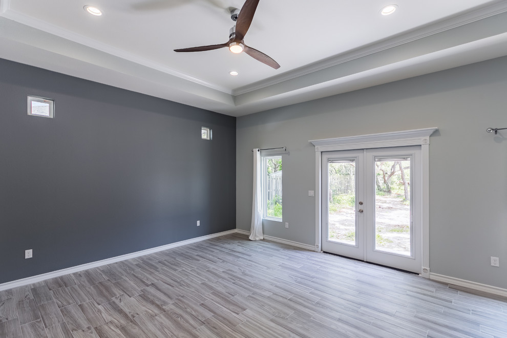 Large beach style master porcelain tile bedroom photo in Austin with gray walls and no fireplace