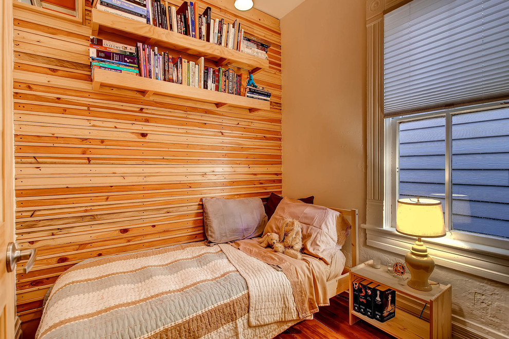 Cette image montre une petite chambre d'amis chalet avec un mur blanc, un sol en bois brun et aucune cheminée.