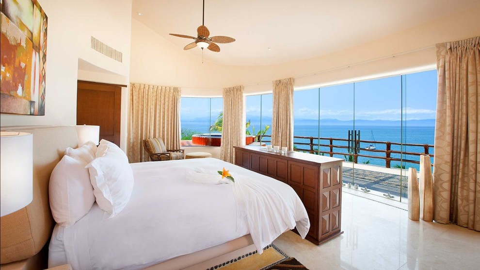 Diseño de dormitorio tropical sin chimenea con paredes beige