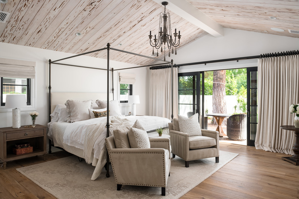 Klassisches Schlafzimmer mit weißer Wandfarbe, braunem Holzboden und braunem Boden in Phoenix