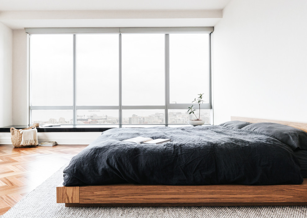 Inspiration for a large scandinavian guest bedroom in San Francisco with white walls, medium hardwood flooring, no fireplace and brown floors.
