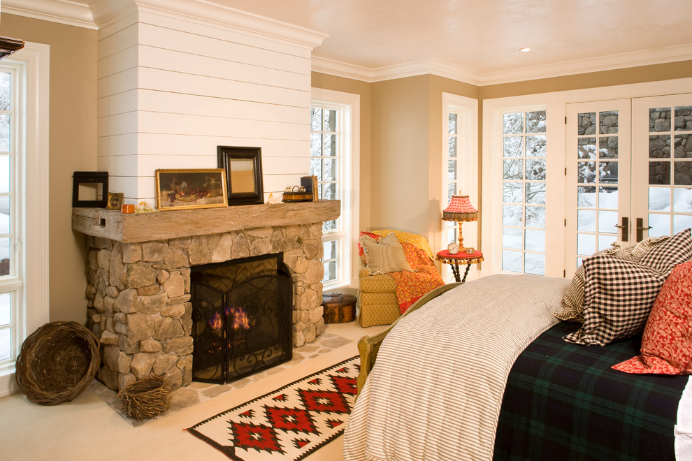 Foto de dormitorio tradicional con paredes beige, moqueta, todas las chimeneas y marco de chimenea de piedra