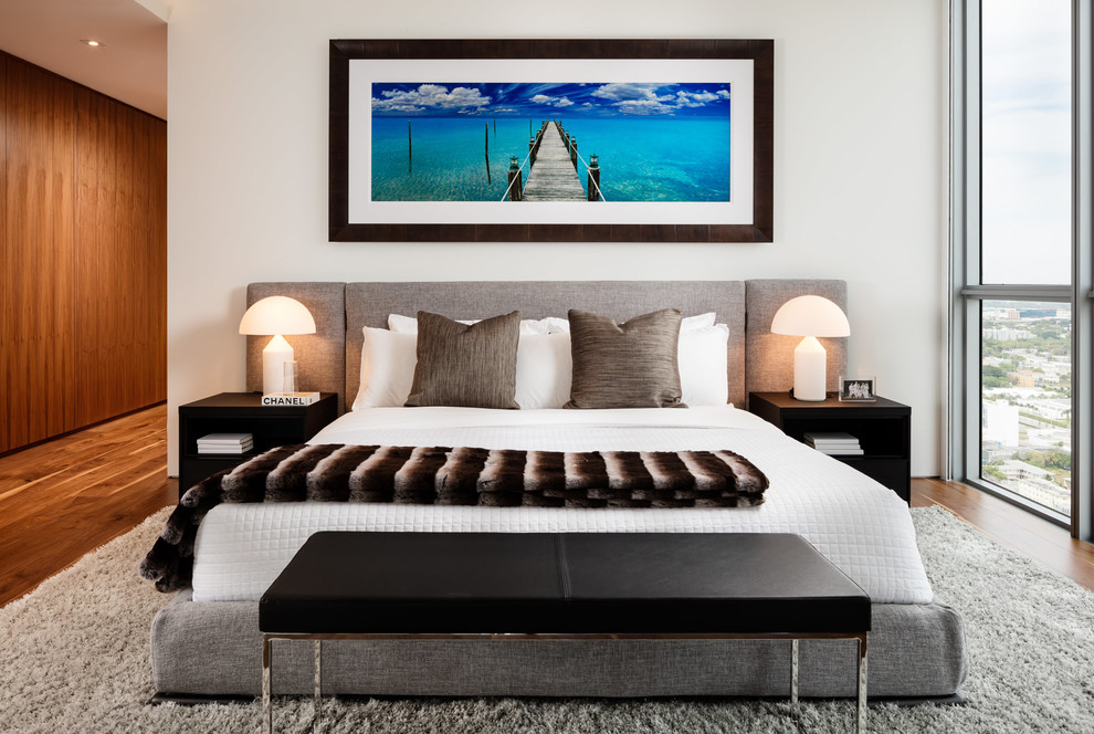 Modernes Schlafzimmer mit weißer Wandfarbe und braunem Holzboden in Sonstige