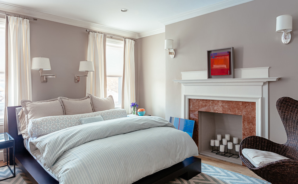Imagen de dormitorio principal clásico renovado con paredes grises, suelo de madera en tonos medios, todas las chimeneas y marco de chimenea de piedra