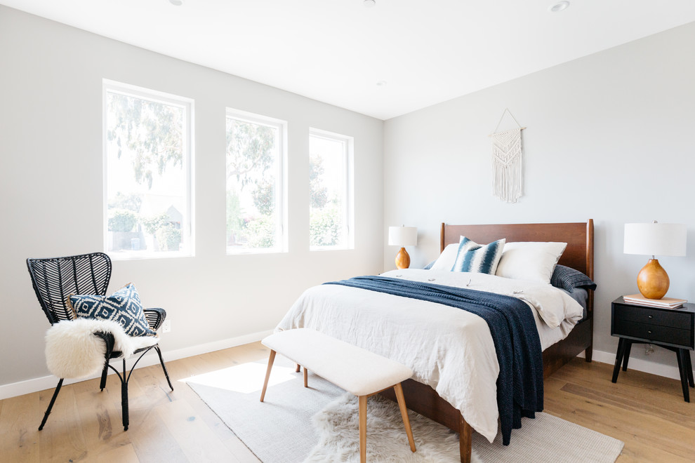 Diseño de dormitorio contemporáneo con paredes grises, suelo de madera en tonos medios y suelo marrón