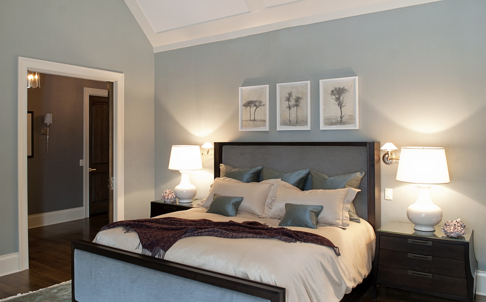 Idée de décoration pour une grande chambre tradition avec un mur bleu et un sol en bois brun.