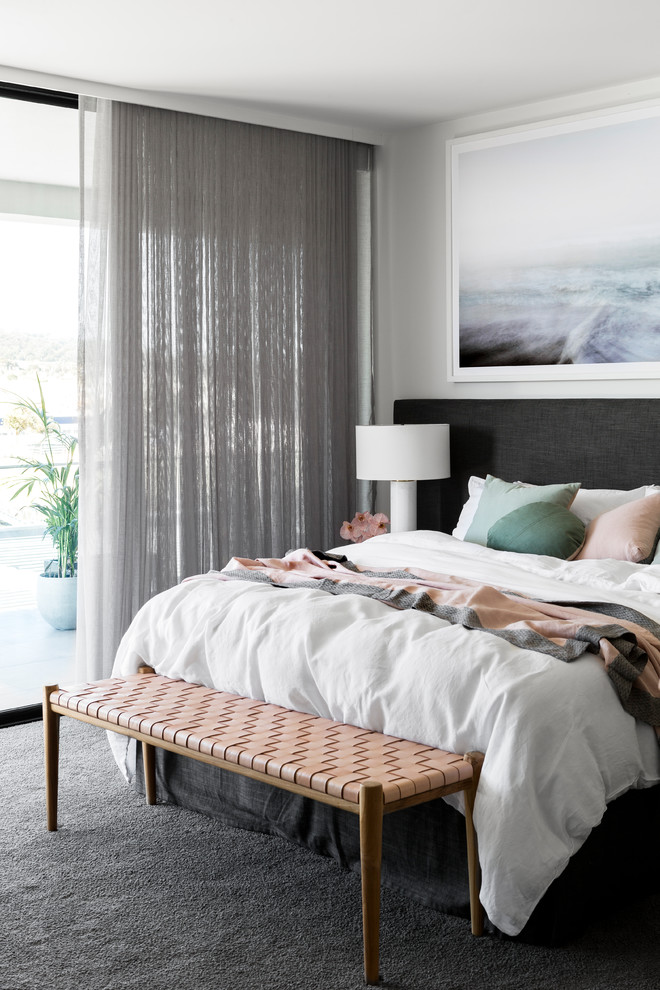 Пример оригинального дизайна: хозяйская спальня в современном стиле с белыми стенами, ковровым покрытием, серым полом и тюлем