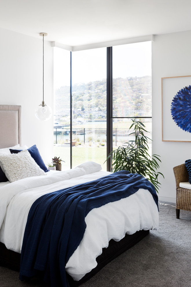 Imagen de habitación de invitados contemporánea con paredes blancas, moqueta y suelo gris