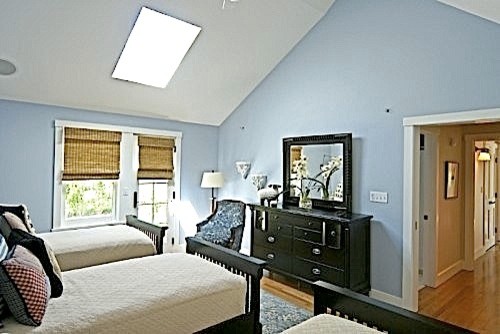 Modelo de habitación de invitados costera con paredes azules y suelo de madera en tonos medios