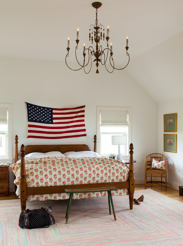 Example of a beach style medium tone wood floor bedroom design in New York with white walls