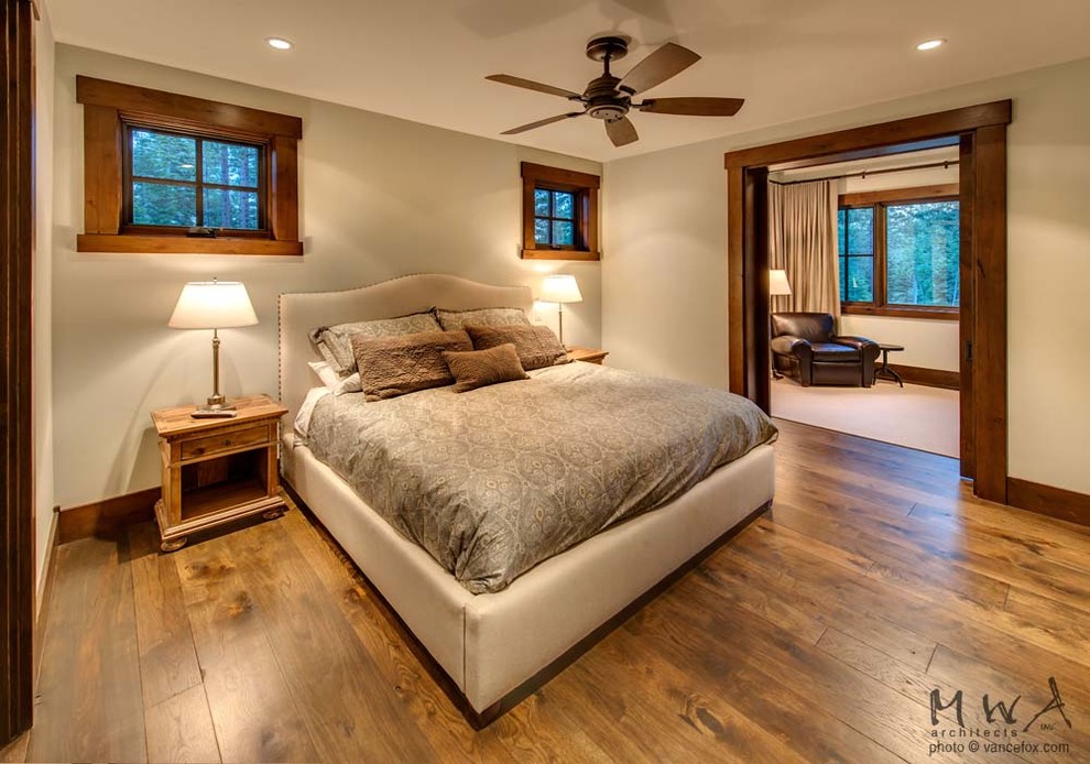 Ispirazione per una camera degli ospiti stile americano di medie dimensioni con pareti beige, pavimento in legno massello medio e pavimento marrone