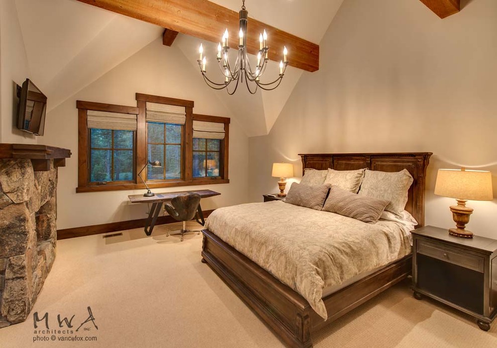 Inspiration pour une grande chambre craftsman avec un mur beige, une cheminée standard, un manteau de cheminée en pierre et un sol beige.