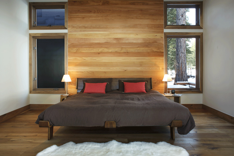 Aménagement d'une chambre montagne avec un mur blanc et un sol en bois brun.
