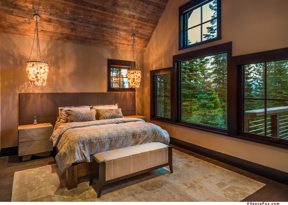 Large mountain style master dark wood floor bedroom photo in Sacramento with beige walls