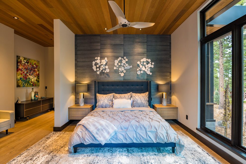 Foto de dormitorio principal contemporáneo grande con suelo de madera en tonos medios, suelo marrón, paredes grises, madera y papel pintado