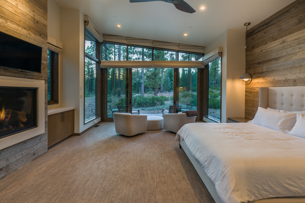 Cette image montre une grande chambre design avec une cheminée standard, un manteau de cheminée en béton et un sol beige.