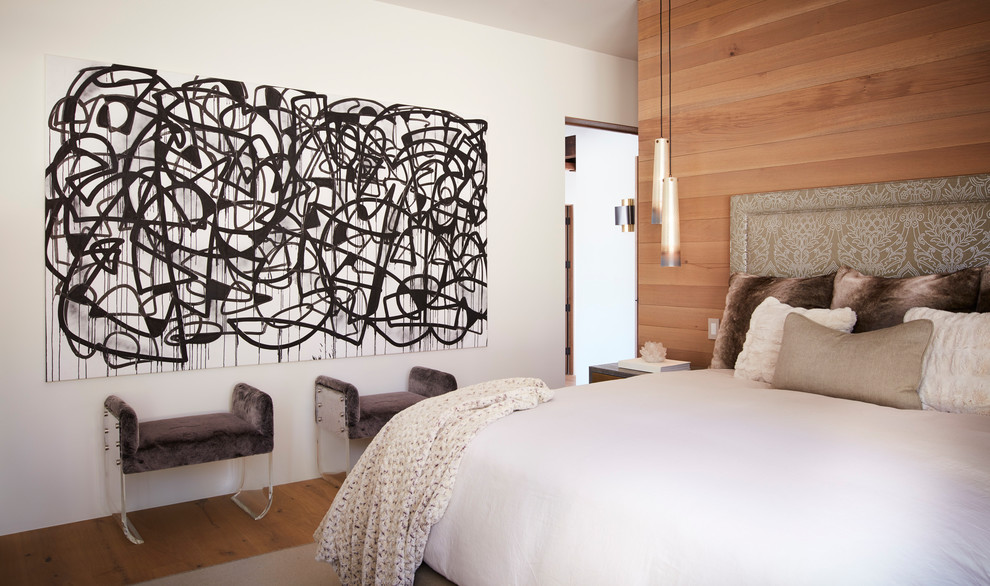 Cette image montre une chambre parentale design de taille moyenne avec un mur blanc, un sol en bois brun et un sol marron.