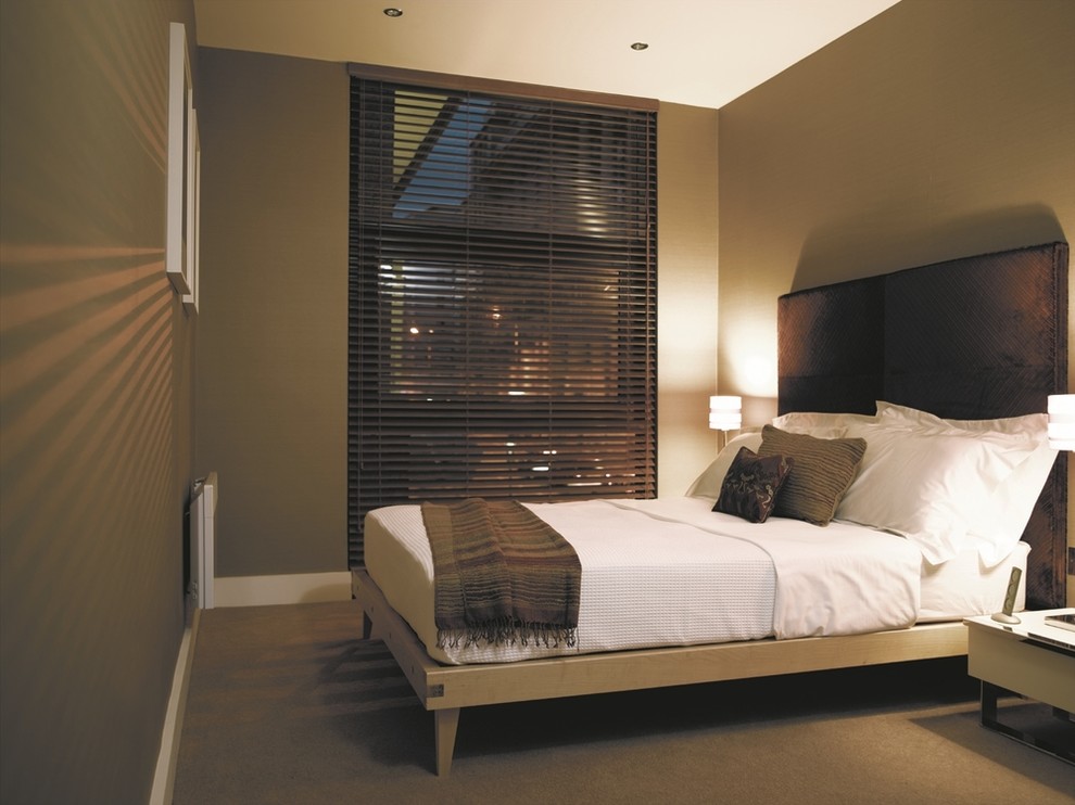 На фото: хозяйская спальня среднего размера в стиле модернизм с зелеными стенами и ковровым покрытием